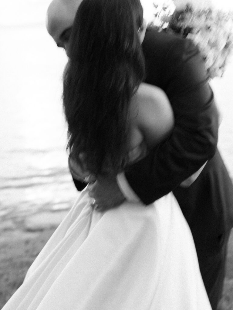 Documentary wedding photo of bride and groom hugging each other.