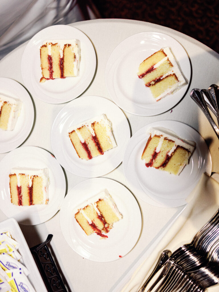 Flash photography of slices of white wedding cake with raspberry filling.