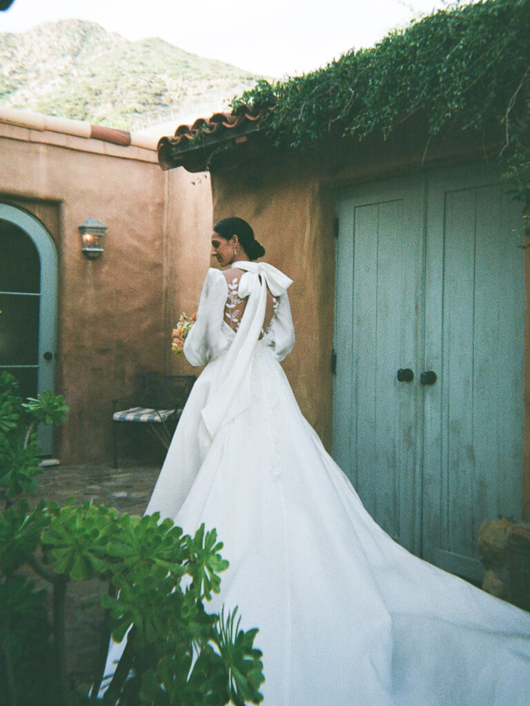 Back of a Leah da Gloria wedding gown with a bow at a wedding venue inspired by Spain.