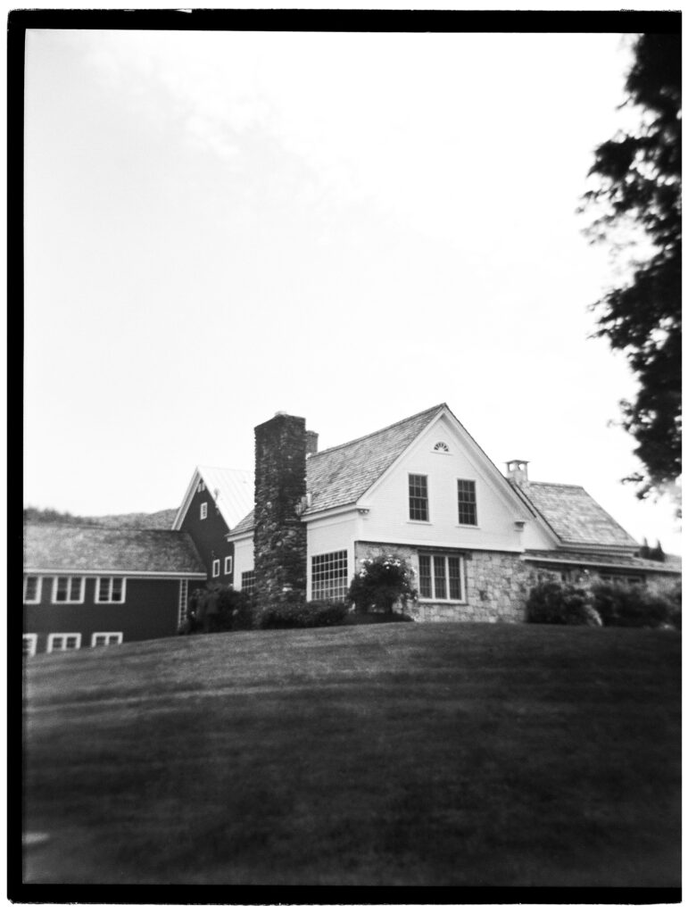 Farm wedding venues in Vermont include Riverside Farm, as seen in this black and white image of the historic barn and farmhouse.
