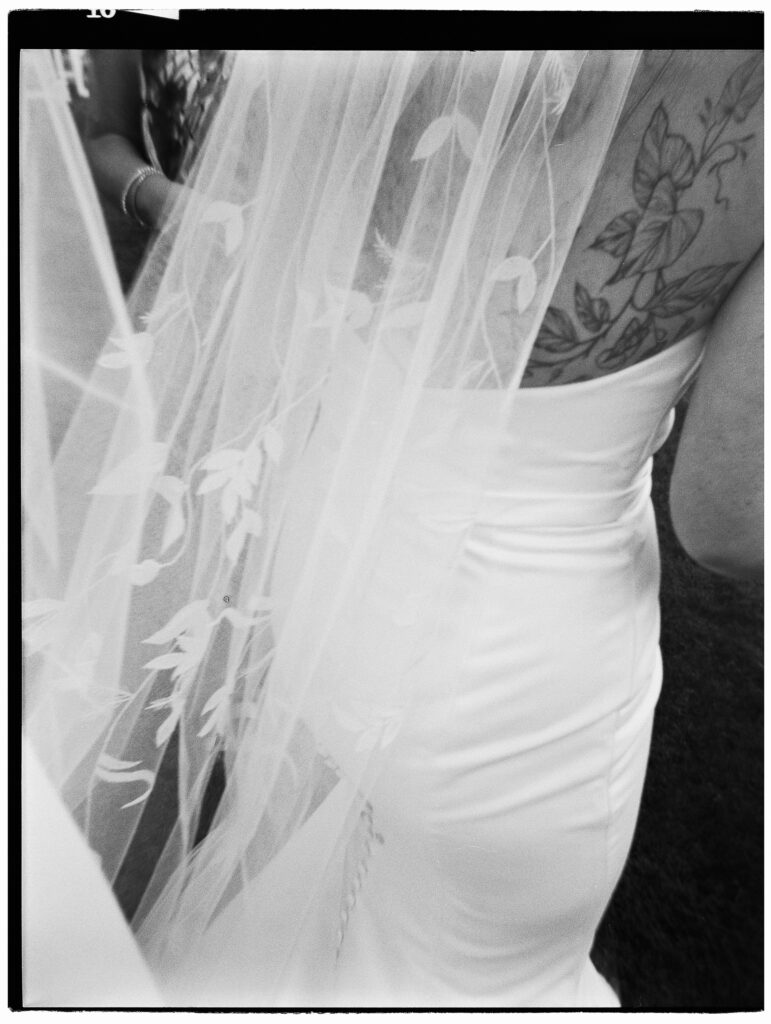 Wedding image shot on a Holga toy camera with HP5 black and white film stock of a bride and her veil.