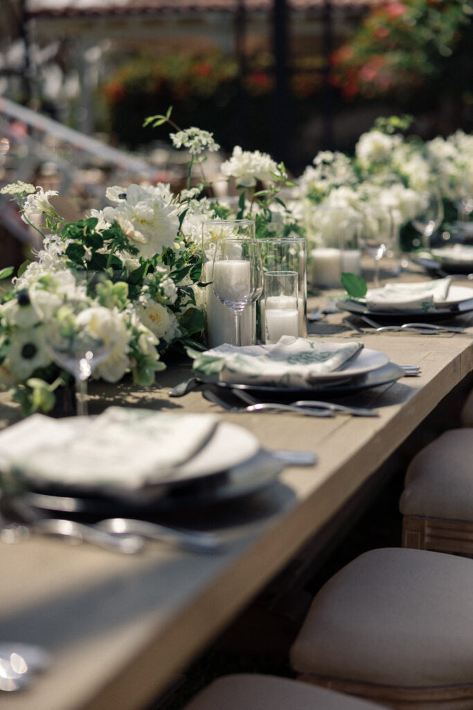 Green and white wedding reception on farmhouse tables at a greenhouse wedding in southern California.