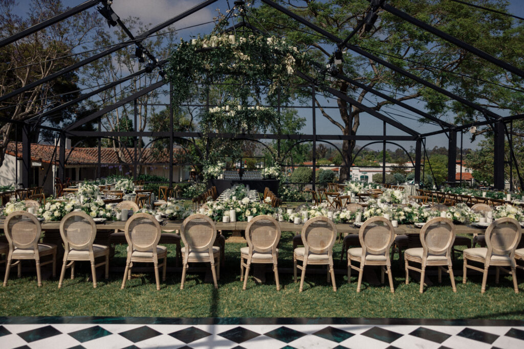 Greenhouse wedding reception with green and white flowers and decor.