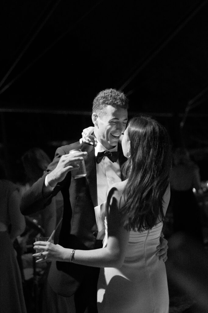 Couple laughing and dancing during wedding reception.